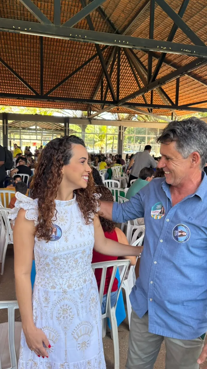Edna Costa com lideranças, em frente às bandeiras